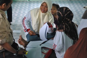 Salah satu Relawan Desa bertanya kepada fasilitator bagaimana cara mengisi pelaporan yang benar.