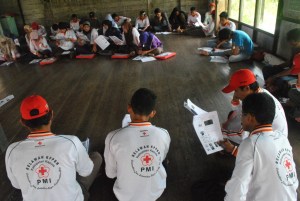 relawan kelurahan mendengarkan penjelasan tentang malaria dari fasilitator