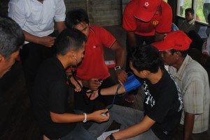relawan kelurahan mencoba belajar menggunakan alat pengukur tekanan darah