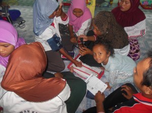 Relawan Desa sedang mencoba belajar menggunakan alat pengukur tekanan darah