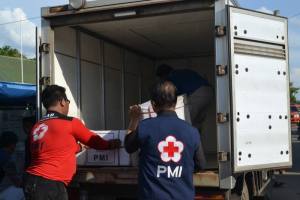 Proses penurunan barang bantuan dari truk PMI 